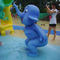 As crianças jogam o elefante pequeno dos pulverizadores de água da associação, animal ereto da fibra de vidro - azul